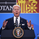 President Joe Biden speaks at a lectern with his hands raised.